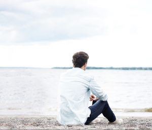 海を座って眺める一人の青年