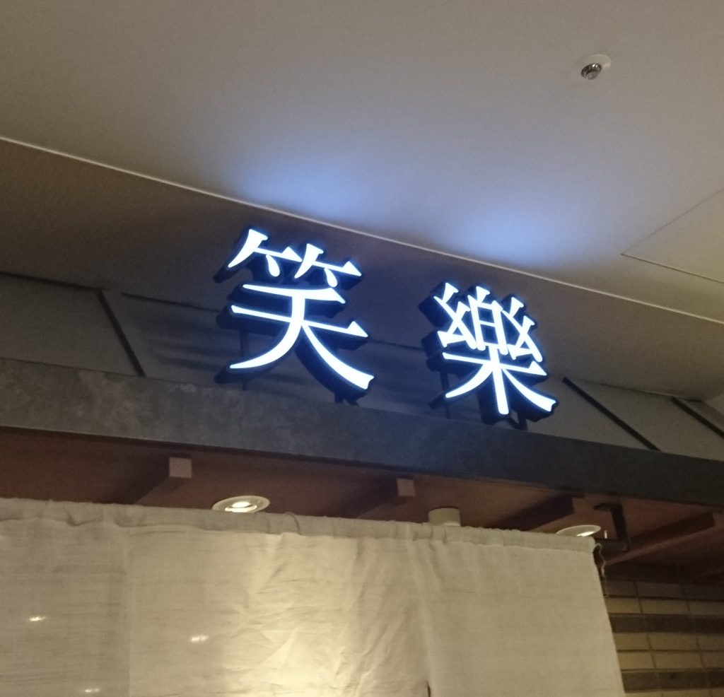入口上の笑楽と書かれた看板 光っている