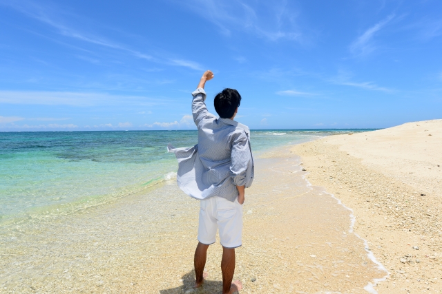 沖縄の海でこぶしを突き上げる男性
