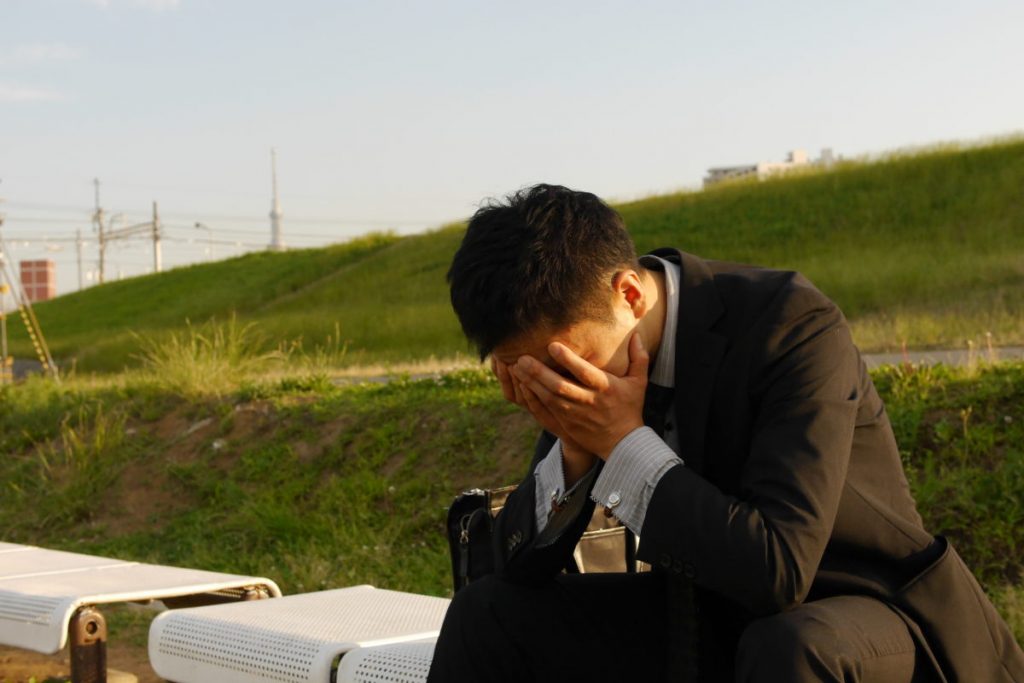 ベンチで落ち込む男性