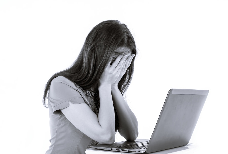 パソコンを見て悲しむ女性　白黒画像